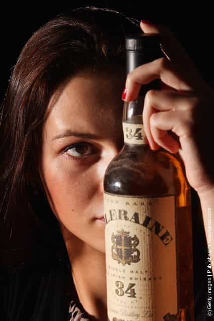 Victoria Kasperovich, an employee at McTears Auctioneers, views a bottle of Coleraine Single Malt Old Irish whiskey