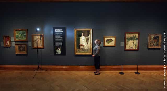 A woman poses near a painting by Edouard Manet entitled Portrait of Mademoiselle Claus from 1868 in the Ashmolean Museum