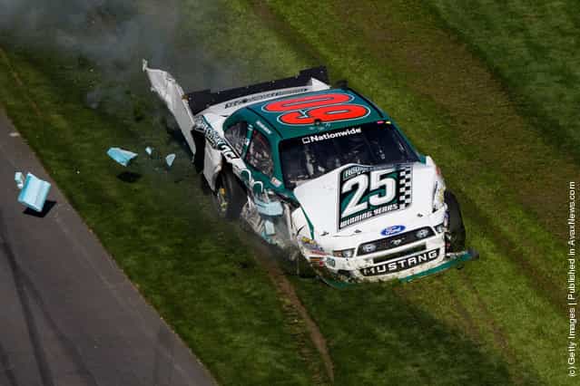 Trevor Bayne drives the wrecked #60 Roush Fenway Racing Ford through the grass after being involved in a last lap on track incident during the NASCAR Nationwide Series DRIVE4COPD 300 at Daytona International Speedway