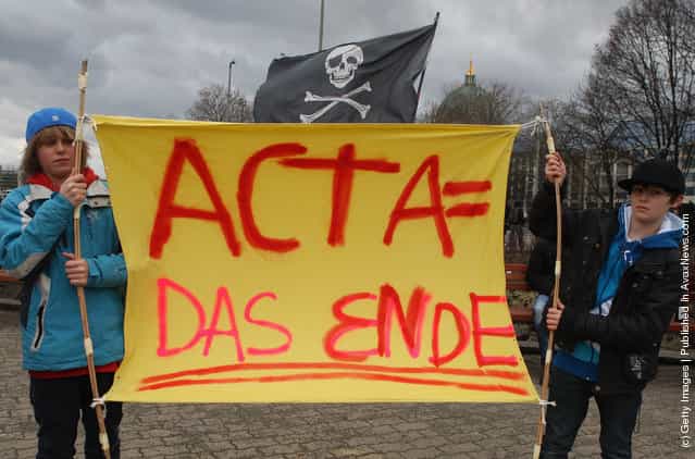 Activists protest from inside the Neptune fountain at Alexanderplatz during a demonstration against the Anti-Counterfeiting Trade Agreement (ACTA)