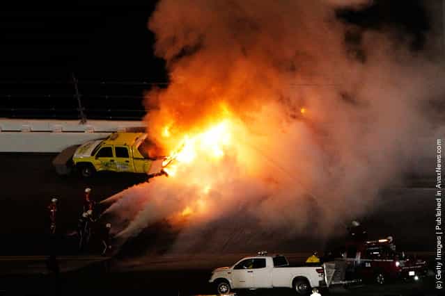 Safety workers try to extinguish a fire from a jet dryer after being hit by Juan Pablo Montoya, driver of the #42 Target Chevrolet, under caution during the NASCAR Sprint Cup Series Daytona 500 at Daytona International Speedway