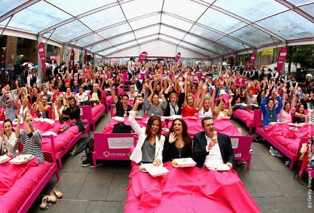 People wait in beds during the The Worlds Biggest Breakfast in Bed Guinness World Record Attempt at Martin Place in Sydney, Australia