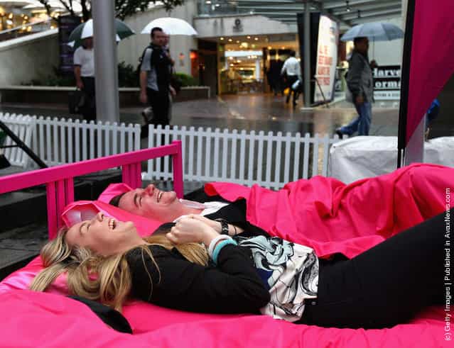 People wait in beds during the The Worlds Biggest Breakfast in Bed Guinness World Record Attempt at Martin Place in Sydney, Australia
