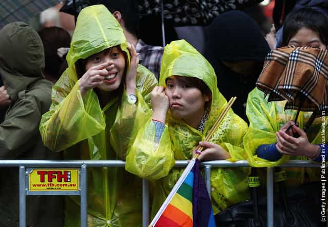 Crowd members attempt to keep dry with umbrellas and ponchos prior to the 2012 Sydney Gay & Lesbian Mardi Gras Parade