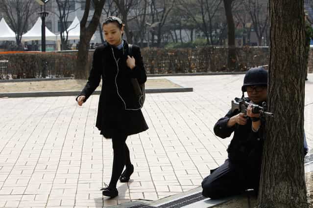 A woman walk by South Korean police during a anti-terror exercise