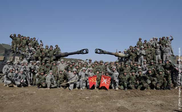 U.S. soldiers from 145th Field Artillery Battalion deployed from the United States and South Korean soldiers chant their slogans on the Paladin self propelled gun after the Foal Eagle training exercise at firing point 180 at the Rodriguez Live Fire Range on March 15, 2012 in Pocheon, South Korea