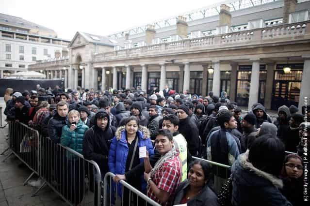Queues wait outside the Apple Store in Covent Garden to buy the new iPad in London, England