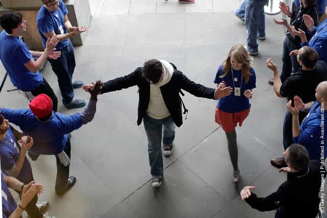 A shopper is welcomed into the Apple Store by staff in Covent Garden to buy a new iPad on March 16, 2012 in London