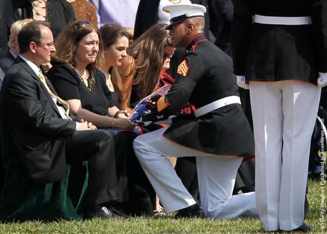 Marine Corps Sergeant Major Eric J. Stockton (R) presents a U.S. flag to parents Robert (L) and Robin Stacey (2nd L) during the burial service of Marine Corps Sergeant William C. Stacey of Redding, California