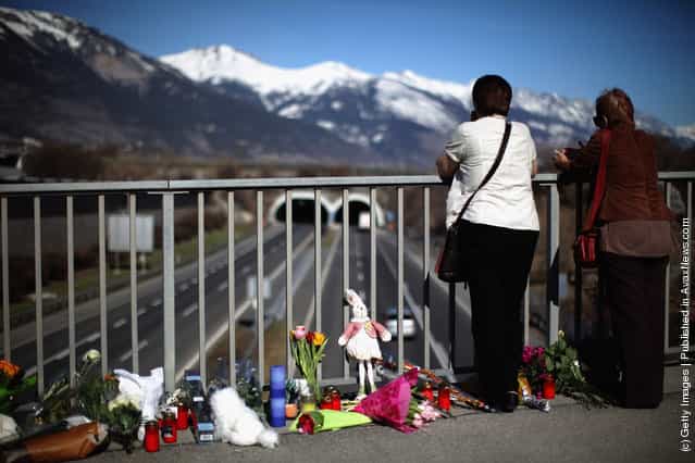 Members of the public lay flowers on a bridge near to the road tunnel where the 22 Belgian school children, four teachers and two drivers died in a coach crash, on March 15, 2012 in Sierre, Valais, Switzerland