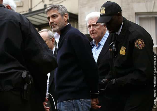 Actor George Clooney (L) is arrested with his father Nick Clooney (2R) during a demonstration outside the Embassy of Sudan March 16, 2012 in Washington