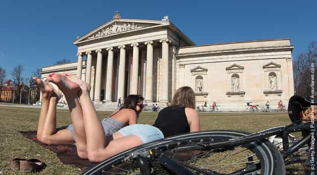 Young girls are taking a sunbath in front of Glyptothek, museum for Greek and Roman art on March 17, 2012 in Muenchen, Germany