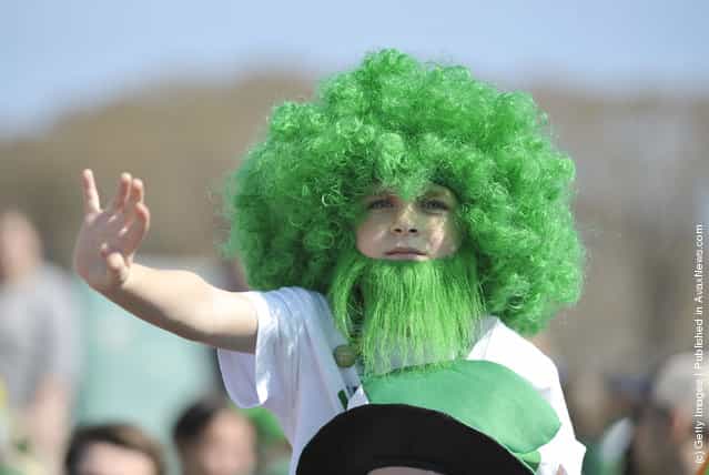 Max Long, 7, sports a green afro and beard as he watches the St. Patricks Day parade from his fathers shoulders on March 17, 2012 in Chicago