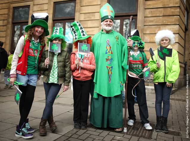 Children stand with a man dressed as St Patrick before taking part in a St Patricks day parade on March 18, 2012 in London