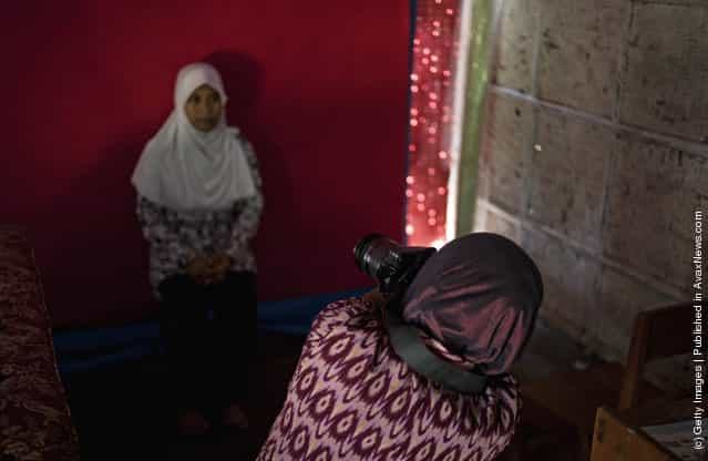 Armless professional photographer Rusidah, 44, takes a customers portrait