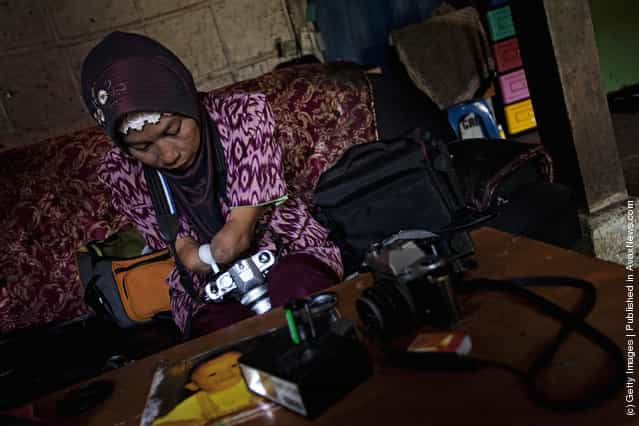 Armless professional photographer Rusidah, 44, carries out camera maintenance