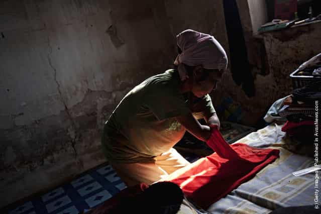 Armless professional photographer Rusidah, 44, folds laundry inside her house cum studio
