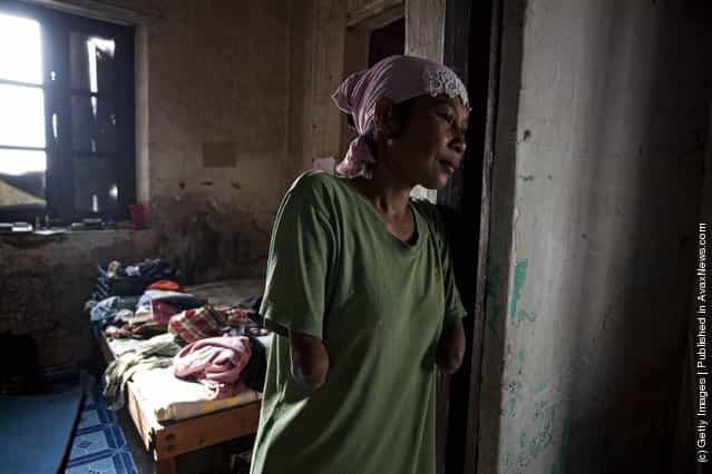 Armless professional photographer Rusidah, 44, stands inside her house cum studio