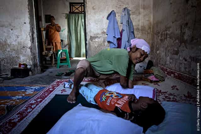  Armless professional photographer Rusidah, 44, cares for her nephew Dayat inside her house cum studio