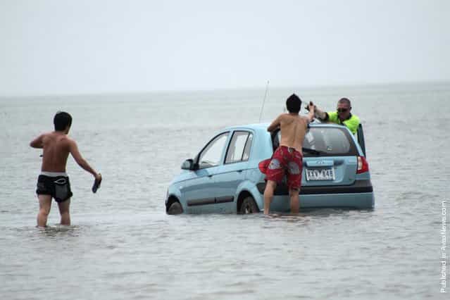 Three Japanese tourists had to abandon plans to drive to Stradbroke Island off the Queensland coast when their hire car became bogged in mangrove mud, on March 15, 2012 near Stradbroke Island, Australia