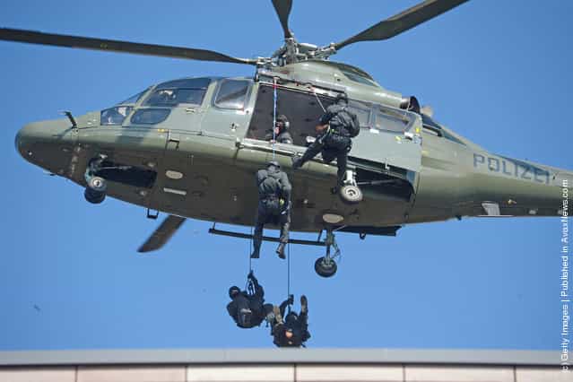 Members of Germanys elite police unit, the Spezialeinsatzkommando, or SEK, demonstrate an abseil deployment from a helicopter during a media event