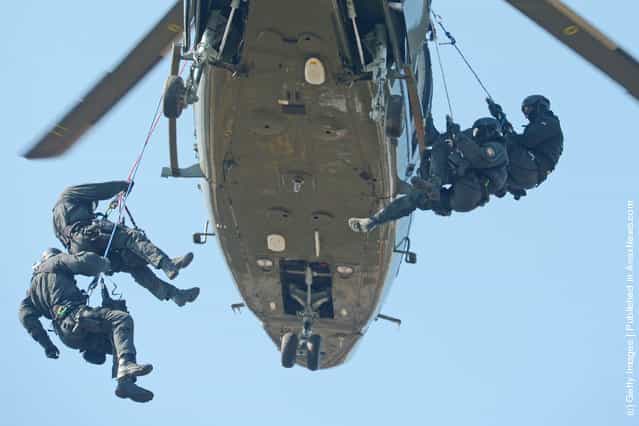 Members of Germanys elite police unit, the Spezialeinsatzkommando, or SEK, demonstrate an abseil deployment from a helicopter during a media event