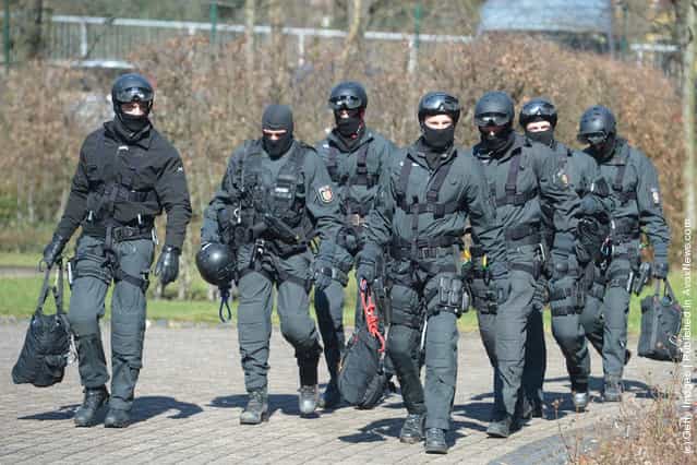 Members of Germanys elite police unit, the Spezialeinsatzkommando, or SEK, leave the building after demonstrating an abseil deployment from a helicopter during a media event
