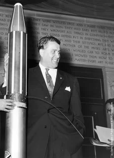German-born American engineer Dr Wernher von Braun (1912 - 1977) with a model of the Explorer orbiting space satellite which he designed, 1958