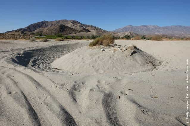 Desert sand is worn away by dirt bikers driving in circles near Travertine Point in an area where a controversial development would create a new town for nearly 40,000 people on the northwest shore of the biggest lake in California, the Salton Sea