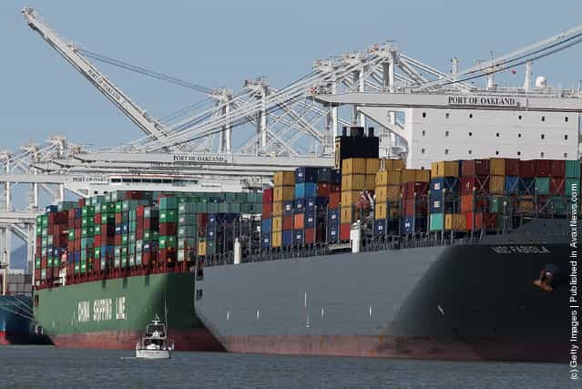 The container ship MSC Fabiola (R) is seen docked at the Port of Oakland on March 22, 2012, in Oakland, California