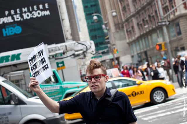 A man holds up a sign advertising comedy shows to people in Times Square on March 23, 2012 in New York City