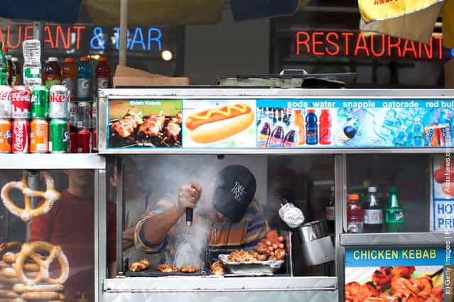 A food cart vendor cooks food in Times Square on March 23, 2012 in New York City