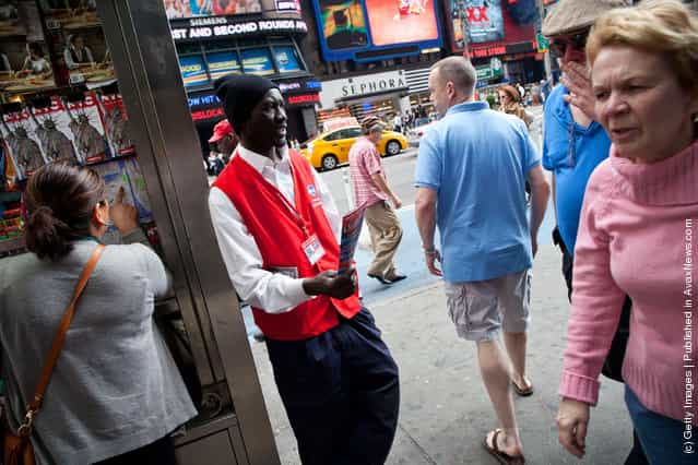 A Grayline bus tours worker hands out flyers to people in Times Square