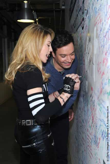 Jimmy Fallon and Madonna sign the Facebook wall before their livestream interview at the Facebook offices