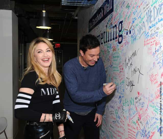 Jimmy Fallon and Madonna sign the Facebook wall before their livestream interview at the Facebook offices
