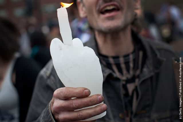 An Occupy Wall Street protester holds up a candle in the shape of a hand giving the middle finger in Union Square at the end of a march from Zuccotti Park