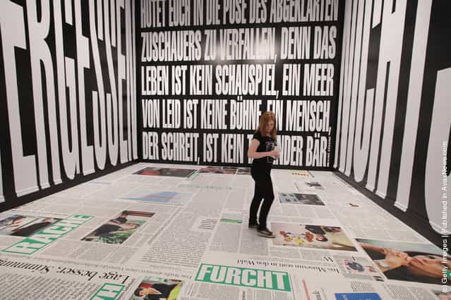 A young woman walks through an installation by artist Barbara Kruger at the exhibition ARTandPRESS at Martin Gropius Bau