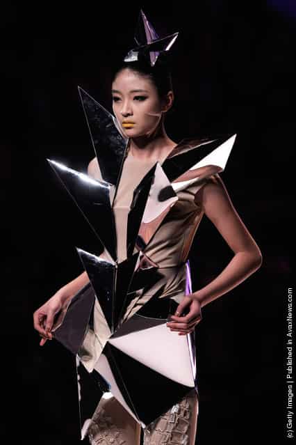 A model showcases designs on the catwalk during the Hempel award the 20th China intemational young fashion designers contest at Beijing hotel