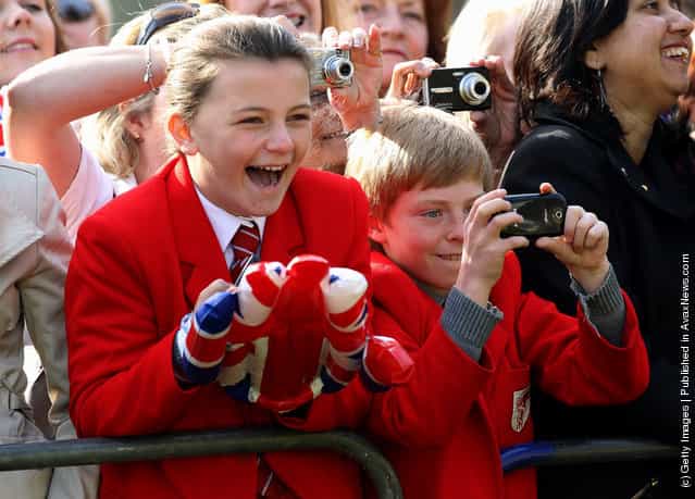 School children take photographs as Queen Elizabeth II arrives in Valentine's Park Redbridge as part of her Diamond Jubilee tour of the UK