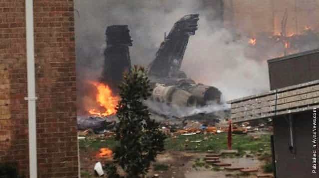 The fuselage of an F/A-18 Hornet smolders after crashing into a residential building in Virginia Beach, Va., April 6, 2012. Authorities said it was miraculous that no one was killed