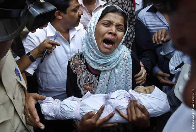 Reshma Bano wails as she holds the body of her 3-month-old daughter Neha Afreen outside a hospital morgue in Bangalore, India