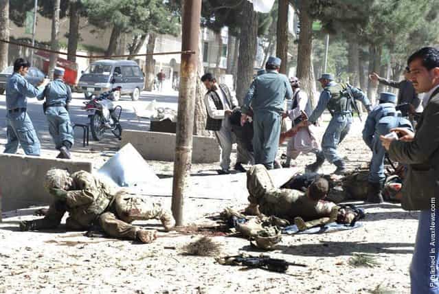 Wounded U.S. soldiers lie on the ground at the scene of a suicide attack in Maimanah, Afghanistan, on April 4, 2012. A suicide bomber blew himself up, killing at least 10 people, including three NATO service members