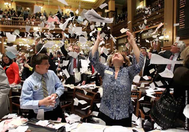 Georgia state Rep. Donna Sheldon, R-Dacula, throws paper into the air next to Thomas Allison after House Majority Leader Rep. Larry O'Neal yelled, [Sine Die]. The proclamation, from the Latin [without day], ended the 2012 Legislative session at midnight at the Capitol in Atlanta, Ga., March 29, 2012