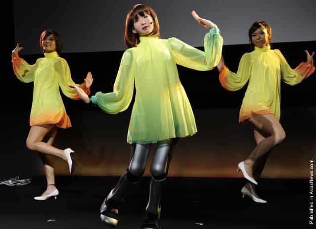HRP-4C, a five-foot humanoid robot developed at Japans National Institute of Advanced Industrial Science and Technology, sings and dances with performers at the Digital Contents Expo in Tokyo on October 17, 2010. The robot runs entertainment software called Choreonoid, a name formed from the words [choreograph] and [humanoid]