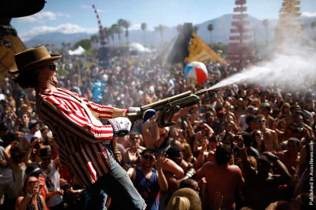 People dance under water sprayed from hoses at the Do Lab at Coachella 2012, on April 14, 2012