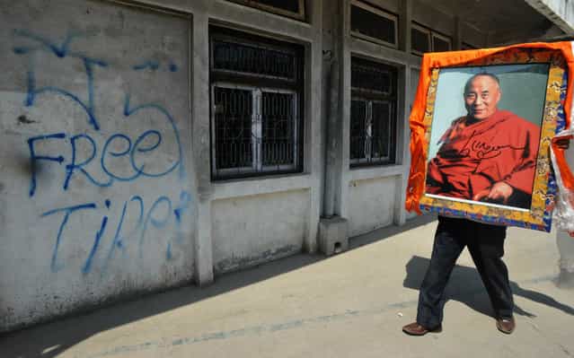 An exiled Tibetan carries a portrait of the Dalai Lama after celebrating the 23rd birthday of the Panchen Lama at the Tibetan Welfare Centre in Boudha, Kathmandu, Nepal, on April 25. Tibetans in exile have demanded the release of the Panchen Lama, who disappeared into Chinese custody in 1995 after being chosen by the Dalai Lama, Tibet's exiled spirirual leader. Chinese authorities selected another child as the Panchen Lama, widely seen as Tibetan Buddhism's second-most important spiritual leader