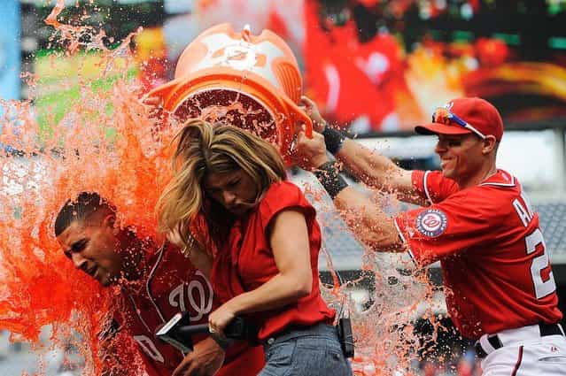 Ian Desmond, left, of the Washington Nationals is doused with Gatorade by his teammates as he is interviewed by MASN's Kristina Akra after hitting the game-winning sacrifice fly in the bottom of the 10th inning against the Miami Marlins at Nationals Park on April 21, Washington, D.C