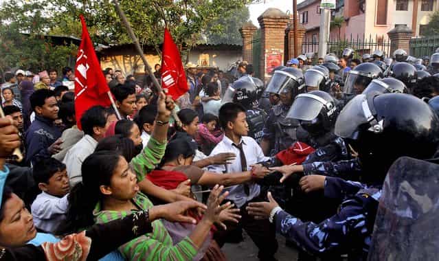 Nepalese police scuffle with illegal squatters residing on the banks of the Bagmati River in Katmandu on May 8, 2012