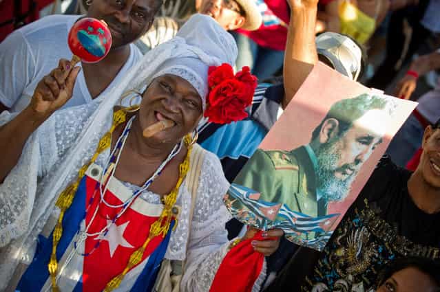 A woman carries a poster of former Cuban President Fidel Castro as thousands of Cubans march under the slogan [Preserve and Perfect Socialism], at Revolution Square in Havana during Labour Day on May 1, 2012