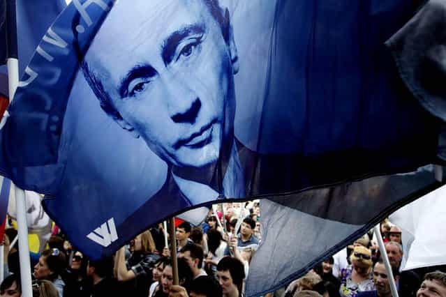 Pro-Putin activists hold flags with portraits of Russian president-elect Vladimir Putin during a rally on the eve of his inauguration as president in Moscow on May 6, 2012